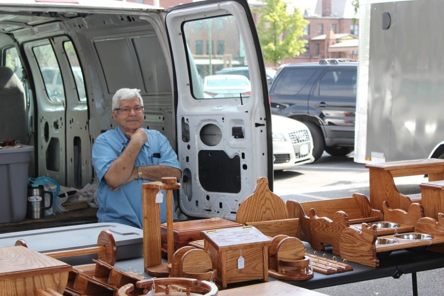 Satisfied with his work, woodworker Jim Dellinger displays the fruit of his hobby at Harrisonburgs Farmers Market.