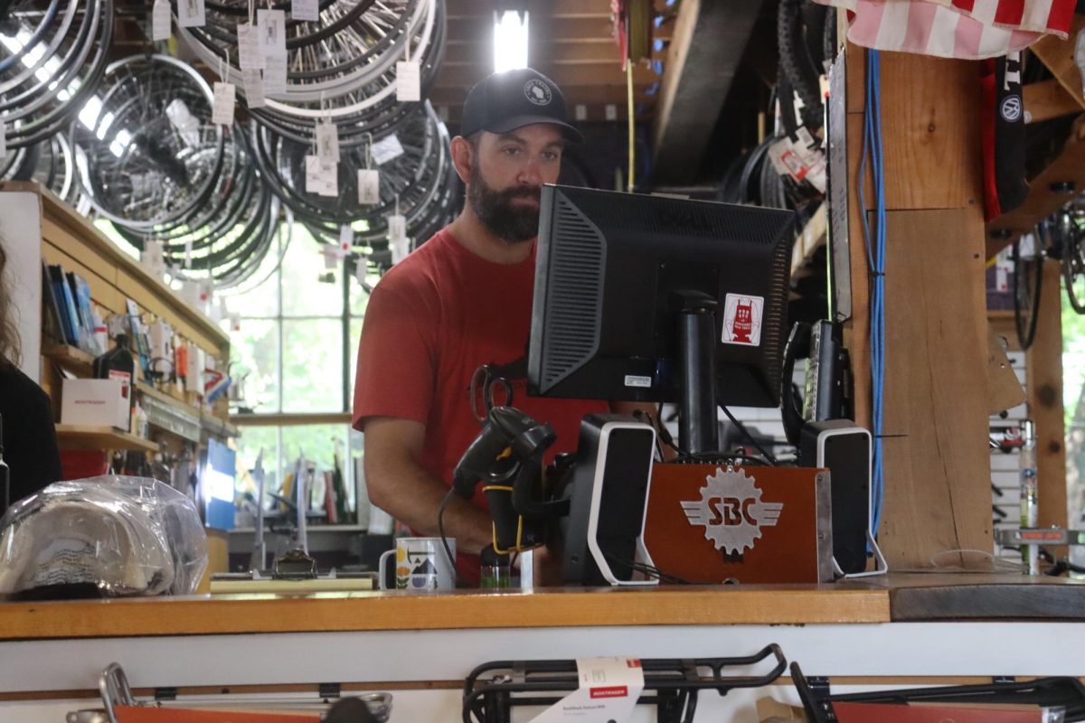 Mark McGranahan stands at the register as Shenandoah Bicycle Company opens for the day. McGranahan has been a resident for 16 years, and has been at SBC since April of 2021.