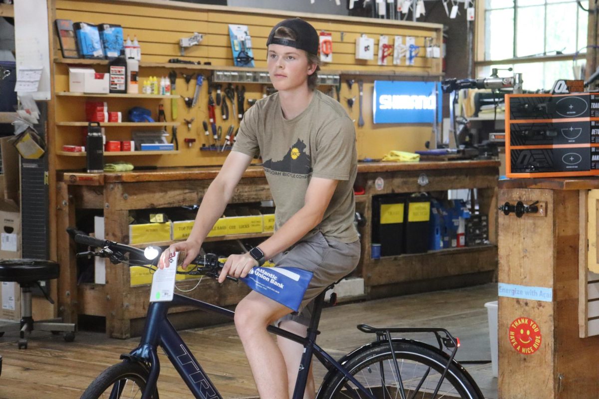 Jonah Lee, an employee at the Shenandoah Bicycle Company, moves one of the many bikes SBC sells. Mountain biking since he was 14, he is among the many people that take up the hobby at a young age. 