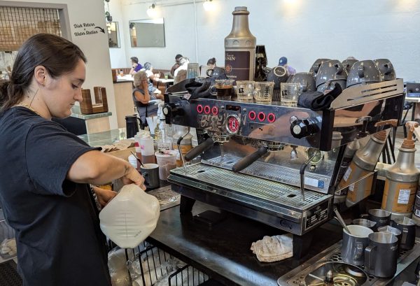 General manager and local barista Rae Eger pours milk into a steaming cup.
