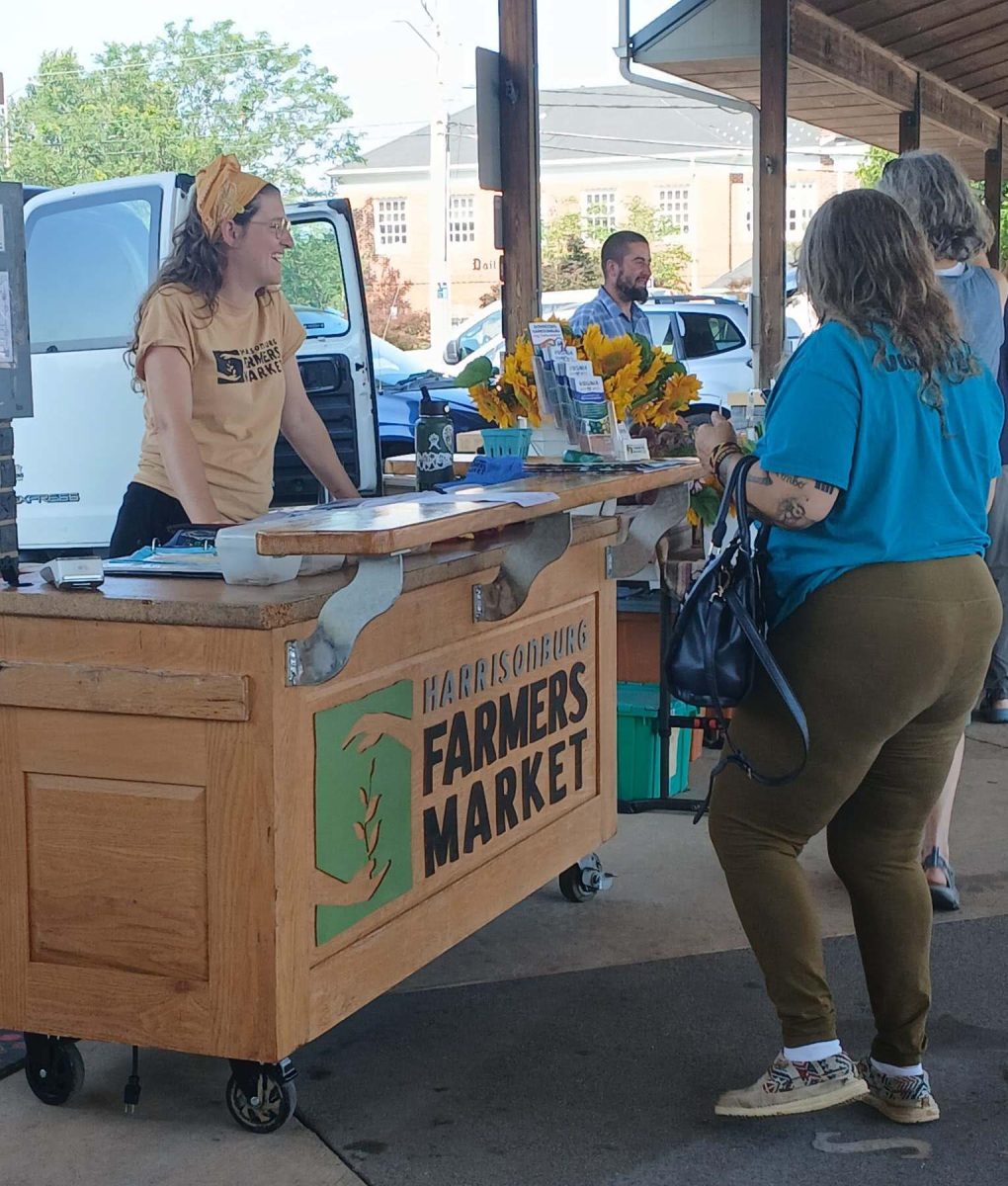 Sarah talking to a customer at the Farmers Market photographed by Lulu Enke